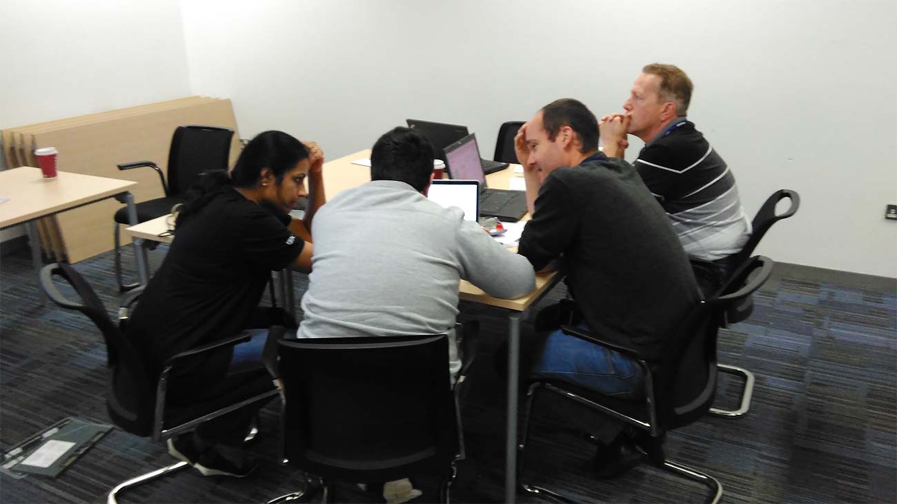 Four IBM engineers working together around a desk