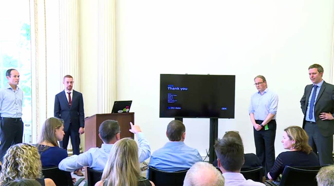 Four IBM employess giving a presentation at a conference