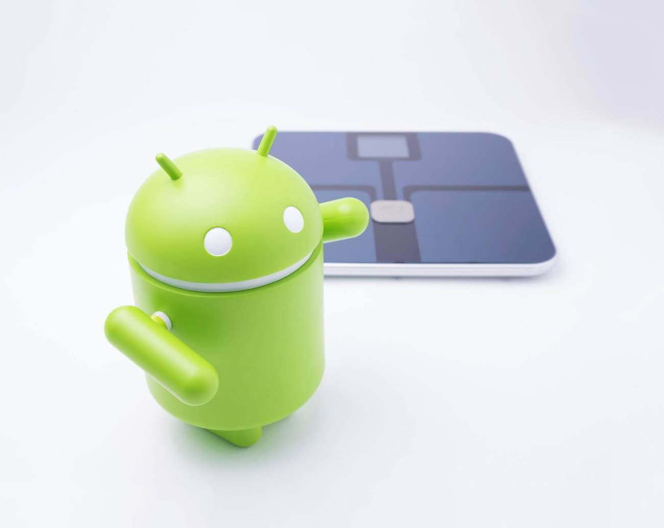 The Android robot in front of the Libra scale